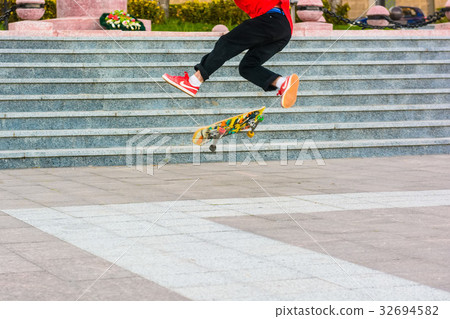 Close up skater does flip trick on skateboard 32694582