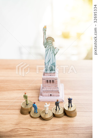 Miniature people standing on coin  32695334