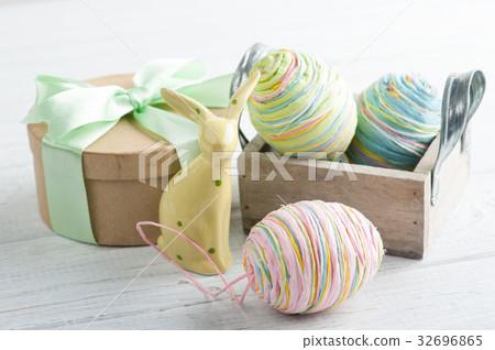Easter composition with gift, toy rabbit and eggs Easter composition with gift, toy rabbit and eggs 32696865