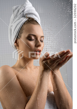 Pretty girl enjoying water stream studio shot Pretty girl enjoying water stream studio shot 32698202