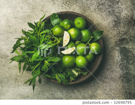 Flatlay of fresh limes and mint in wooden plate 32698795