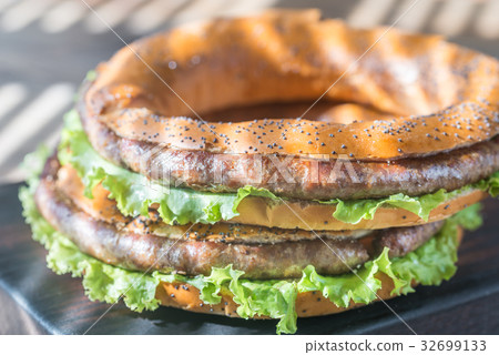 Bagels with fresh lettuce and fried sausage 32699133