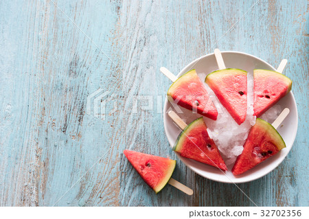 Watermelon slice popsicles on a blue rustic wood  32702356
