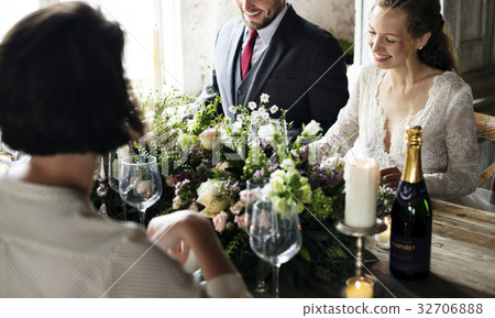 Bride and Groom Having Meal with Friends at Wedding Reception 32706888