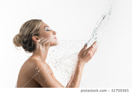 Pretty girl catching water stream in her hands Pretty girl catching water stream in her hands 32709365