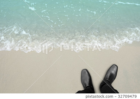 Businessman standing on the beach Businessman standing on the beach 32709479
