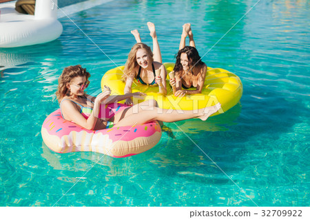 Friends in sunglasses eating ice cream at the pool Friends in sunglasses eating ice cream at the pool 32709922