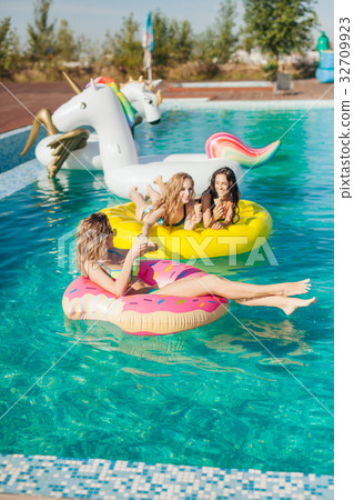 Friends in sunglasses eating ice cream at the pool Friends in sunglasses eating ice cream at the pool 32709923