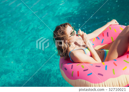 sexy girl in sunglasses eating ice cream in pool  32710021