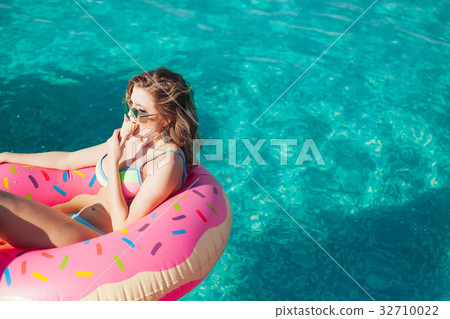 sexy girl in sunglasses eating ice cream in pool  32710022