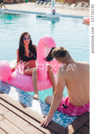 Girl in pool talking to man in the summer 32710130