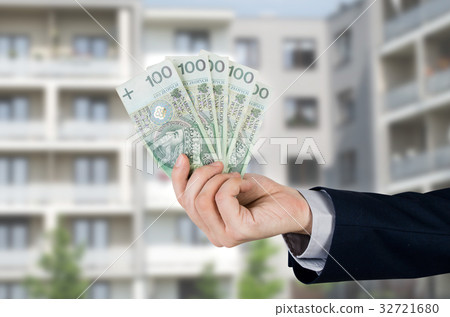 Real estate agent holds Polish money 32721680