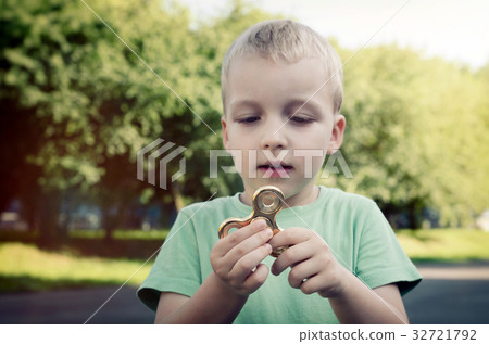 Little boy with a fidget spinner outdoors 32721792