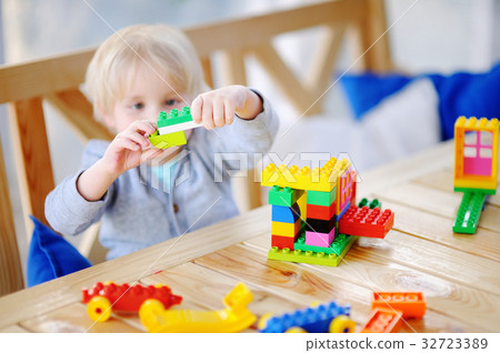 Little boy playing with colorful plastic blocks Little boy playing with colorful plastic blocks 32723389