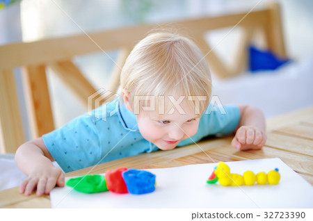 Creative boy playing with colorful modeling clay  32723390