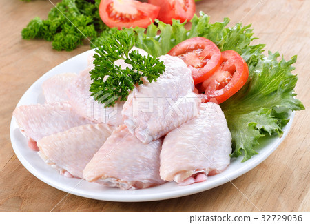 Raw chicken wings with vegetables on wooden board Raw chicken wings with vegetables on wooden board 32729036