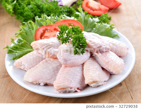 Raw chicken wings with vegetables on wooden board Raw chicken wings with vegetables on wooden board 32729038