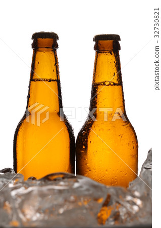 Two bottles of cider in ice cubes. Close up. White 32730821