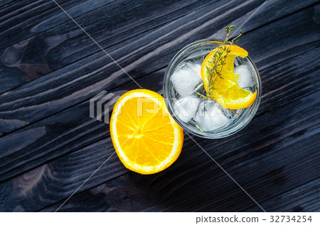 Half lemon and glass with cocktail on wooden table 32734254
