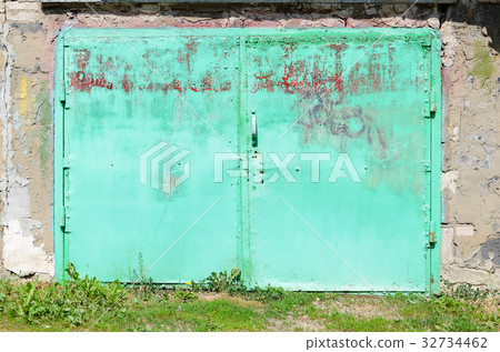 Old green metal garage door 32734462