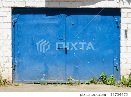 Old blue metal garage door 32734473