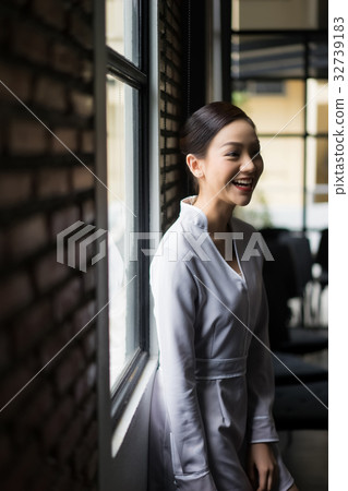 The woman is smiling and seeing someone. 32739183