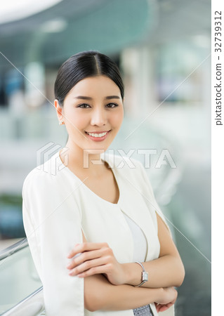 a young woman is crossing her arms and smiling outdoors a young woman is crossing her arms and smiling outdoors 32739312