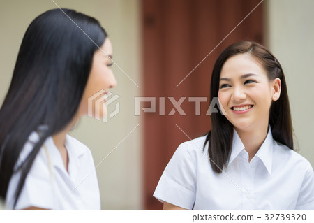 two young girls are looking at each other and smiling two young girls are looking at each other and smiling 32739320