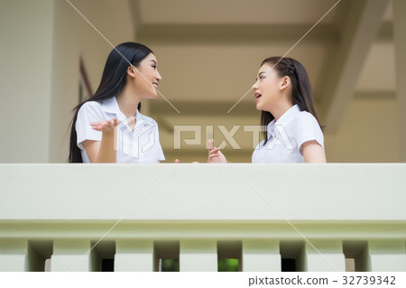 two female students are talking on a balcony two female students are talking on a balcony 32739342