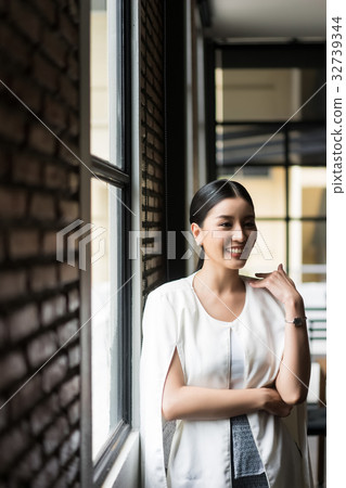 a business woman is standing and smiling with someone a business woman is standing and smiling with someone 32739344