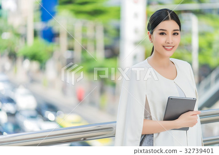 The portrait of girl standing and holding the tablet 32739401