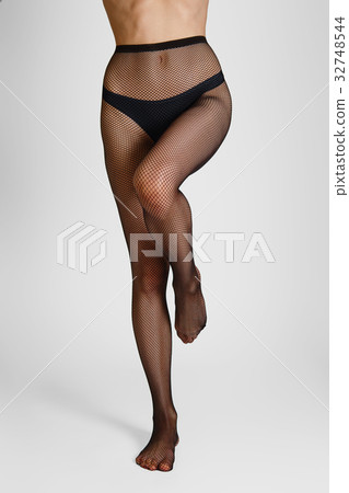 Long slim female legs in elegant fishnet tights 32748544