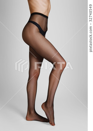 Side view of long female legs in fishnet tights 32748549