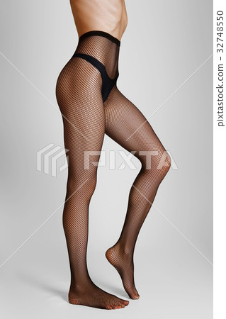 Side view of long female legs in fishnet tights 32748550