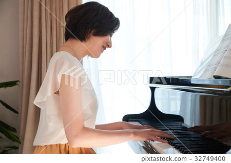 A woman playing the piano 32749400