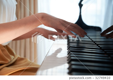 A woman playing the piano 32749410