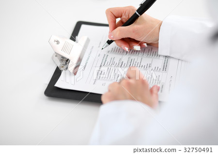 Close-up of a female doctor filling ou Close-up of a female doctor filling ou 32750491