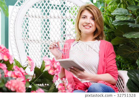 Girl with tablet among flowers 32751328