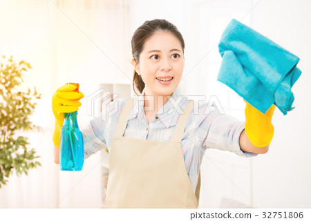 mother cleaning living room window 32751806