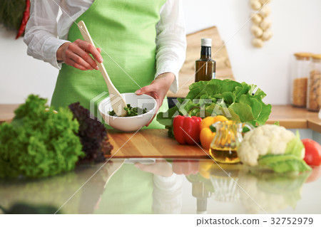 Closeup of human hands cooking vegetables salad in 32752979
