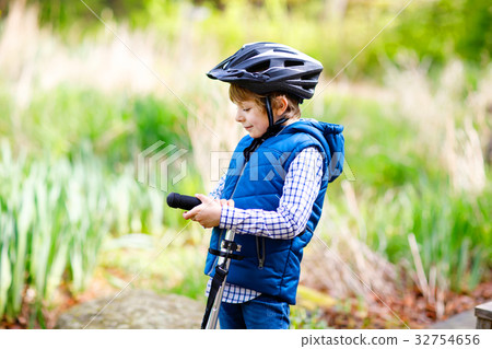 Cute preschool kid boy riding on bicycle in park 32754656