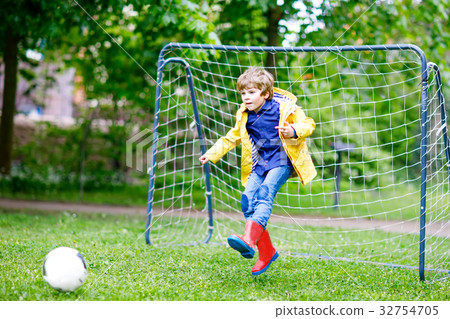 Active cute little kid boy playing soccer and 32754705