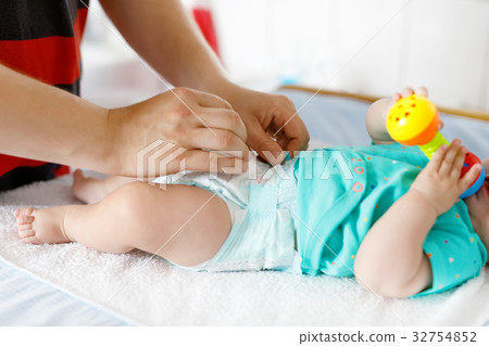 Close-up of father changing diaper of his newborn Close-up of father changing diaper of his newborn 32754852