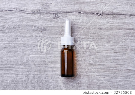 Nasal spray on wooden backdrop. 32755808