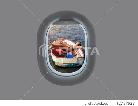female in a wooden boat in the plane window. 32757628