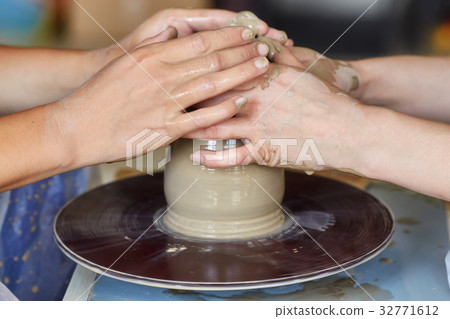 Hands of two people create pot, potter's wheel Hands of two people create pot, potter's wheel 32771612