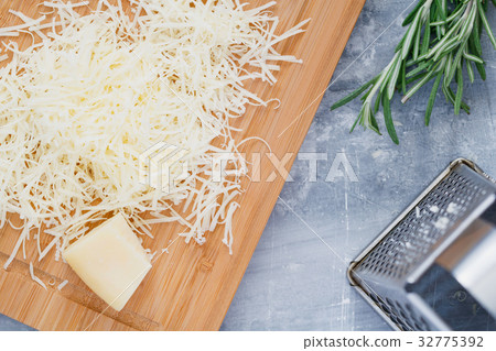 Grated parmesan cheese on a wooden board. Cooking 32775392