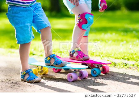 Children riding skateboard in summer park 32775527