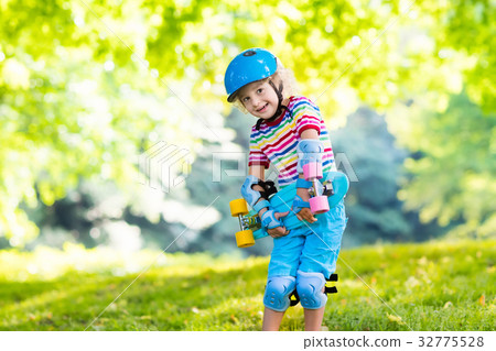 Child riding skateboard in summer park 32775528