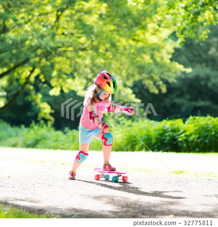 Child riding skateboard in summer park 32775811